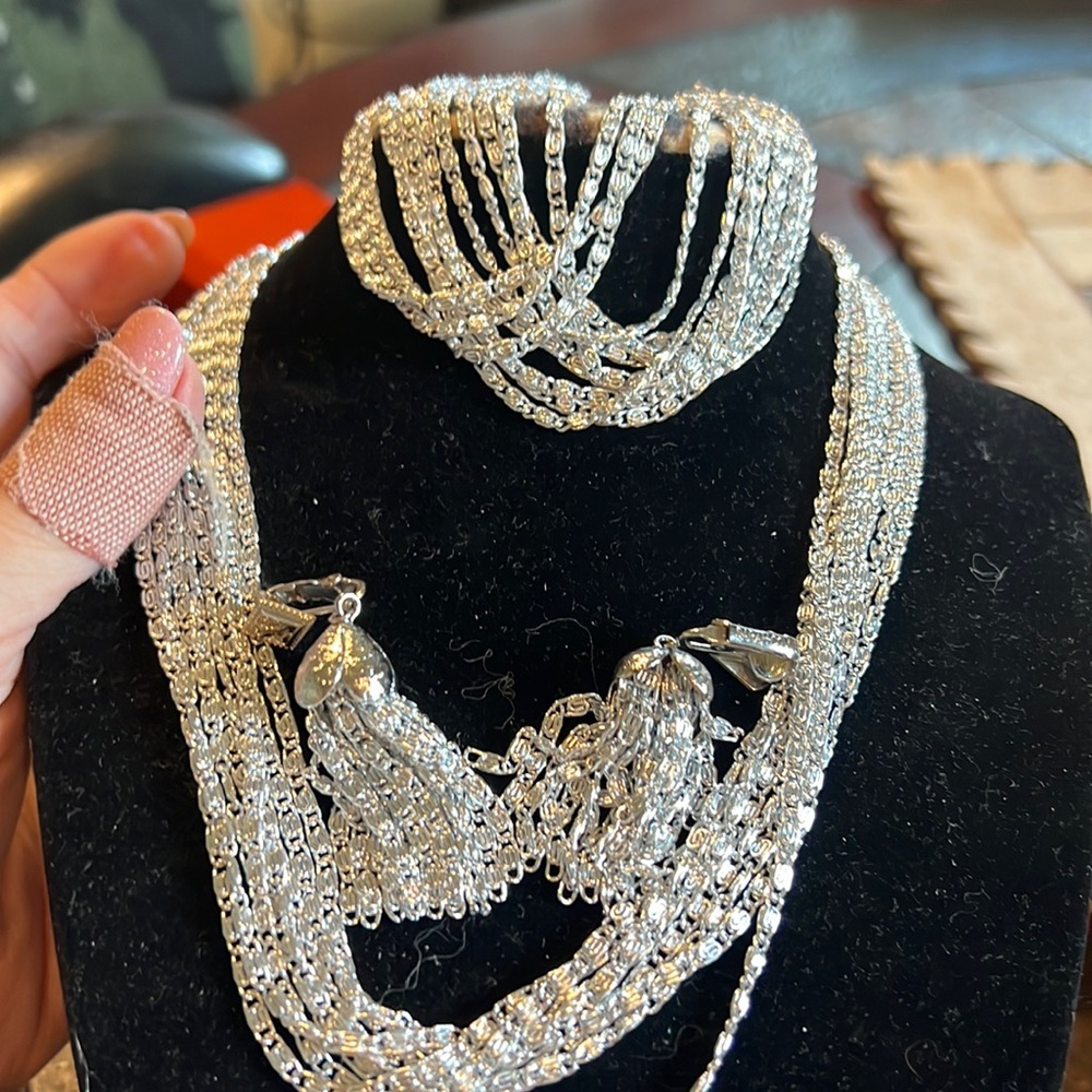 This is a four piece set silver Sarah Coventry bracelet, earrings, and necklace